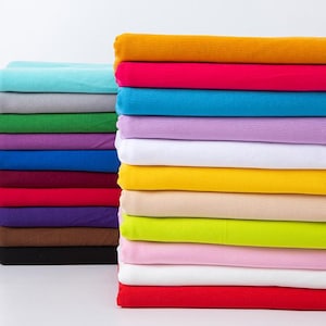 May include: A collection of folded fabric stacks in a range of colours. The left side shows teal, grey, green, purple, blue, red, brown, and black. The right side displays yellow, pink, white, and red. The fabrics are neatly arranged.