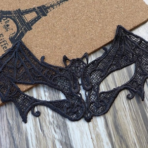Peut inclure: Masque de bal de dentelle noire en forme de chauve-souris avec des détails complexes. Le masque est fait de dentelle noire délicate et a un design d'aile de chauve-souris.
