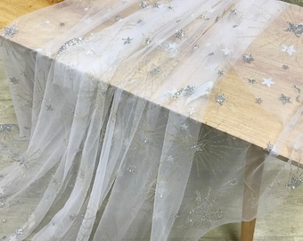 Tela de tul con estrellas y lunas, con brillos dorados y plateados, en color blanco roto para vestidos de noche, tutús y fondos de bodas.