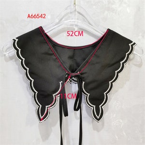 May include: Black faux-pearl embellished collar with a 52-inch circumference and 11-inch ties. The collar is made of a soft, lightweight fabric and features a scalloped edge.