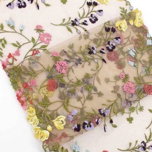 May include: A sheer fabric with a delicate floral embroidery pattern in shades of pink, yellow, blue, green, and purple. The embroidery is detailed and intricate, creating a beautiful and feminine design.