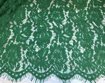 May include: Green floral lace fabric with a scalloped edge and a frayed fringe.