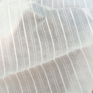 May include: White cotton fabric with thin, vertical stripes. The fabric is sheer and has a slightly textured surface.