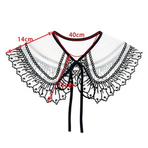 May include: White lace collar with black embroidery and a black ribbon tie. The collar measures 14 inches wide and 40 inches long.