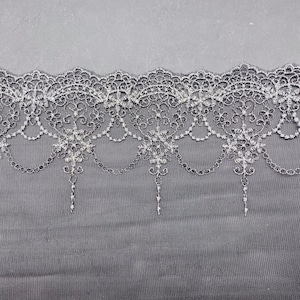 May include: Black lace trim with a delicate floral pattern and a chain-like design. The lace is soft and sheer, and it would be perfect for adding a touch of elegance to any project.