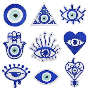 May include: A collection of nine embroidered patches featuring the evil eye symbol in various shapes. The patches are primarily blue and white, with a light blue center. Designs include a circle, triangle, eye, hand, and heart.