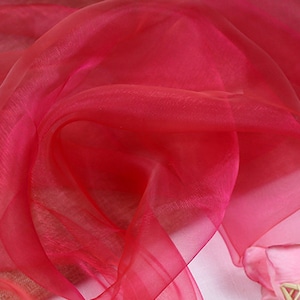 May include: A close-up of a bright red sheer fabric, with a soft, flowing texture. The fabric is draped and folded, creating a delicate and airy appearance.
