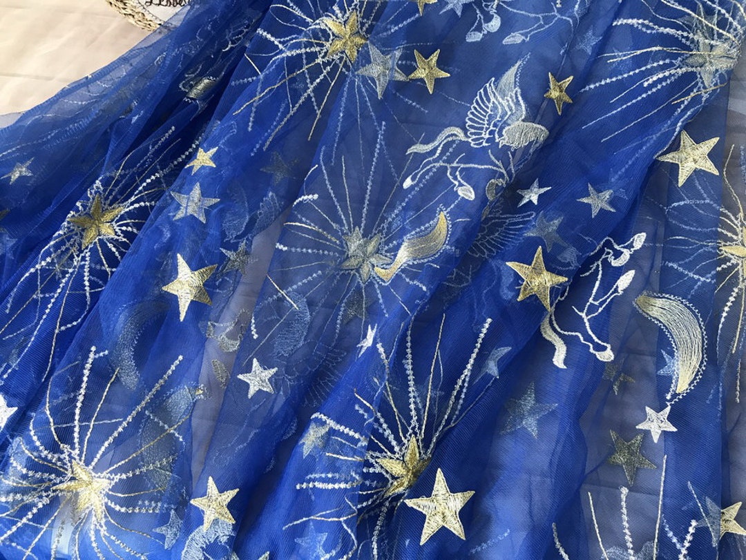 Tela de tul azul rey, tela de encaje bordado con hilo dorado y plateado,  motivos de estrellas, lunas y caballos sobre tela de México