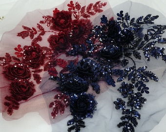 Puede incluir: Dos aplicaciones florales con hojas de lentejuelas y adornos de rosas en 3D. Una aplicación es burdeos y la otra es azul marino.
