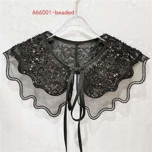 May include: A black beaded lace collar with a scalloped edge and a tie closure. The collar is on a hanger.