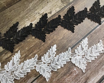 Peut inclure: Deux galons de dentelle avec un motif de feuilles. L'un est noir et l'autre est blanc.