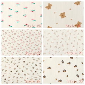 May include: A grid of six fabric swatches featuring various patterns on a cream background. Patterns include pink flowers, brown teddy bears with stars and moons, small pink floral clusters, tiny brown floral sprigs, and brown fruit, labeled Style 25 to 30.