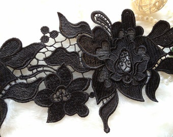 Peut inclure: Garniture en dentelle noire avec un motif floral. La dentelle présente des détails complexes et une texture délicate.