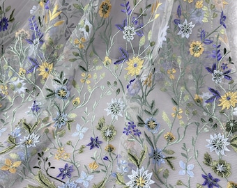 May include: White sheer fabric with embroidered floral designs in shades of blue, yellow, and green.