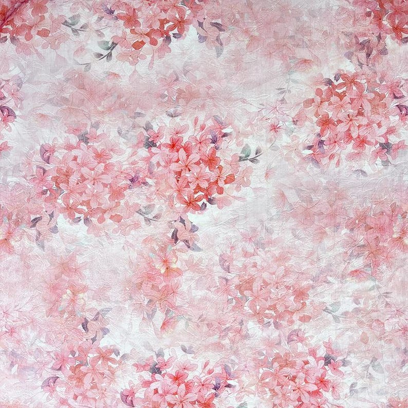 May include: A repeating pattern of soft pink cherry blossom clusters set against a textured, off-white background. The floral design features delicate petals in varying shades of pink with subtle hints of greyish-green leaves throughout.