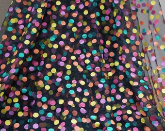 May include: Black sheer fabric with colorful polka dots. The dots are a variety of colors including pink, yellow, orange, green, and teal.
