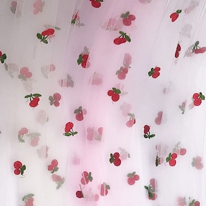 May include: White tulle fabric with a pink ombre effect and a repeating pattern of red cherries with green stems.