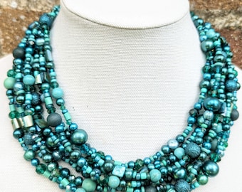 May include: Multi-strand necklace with teal, turquoise, and green beads of various shapes and sizes.