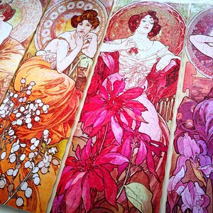 May include: Four panels of a jigsaw puzzle featuring Art Nouveau style illustrations of women with floral accents. The panels feature a woman in a flowing orange dress, a woman in a pink dress, a woman in a purple dress, and a woman in a red dress. The panels are all connected and show a variety of flowers, including lilies, roses, and irises.
