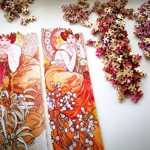 May include: Two framed art prints with a vintage aesthetic. The prints feature women in flowing orange and red dresses with floral details. The prints are surrounded by a white background.