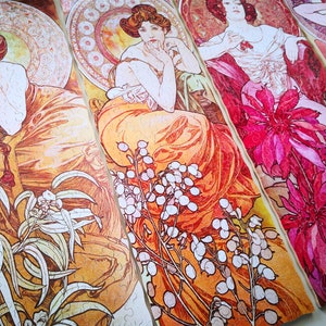 May include: Four jigsaw puzzle pieces featuring Art Nouveau style illustrations of women in elaborate dresses and floral designs. The pieces are arranged in a row, with the women's faces visible in each piece. The colors are vibrant and include shades of orange, pink, red, and white.