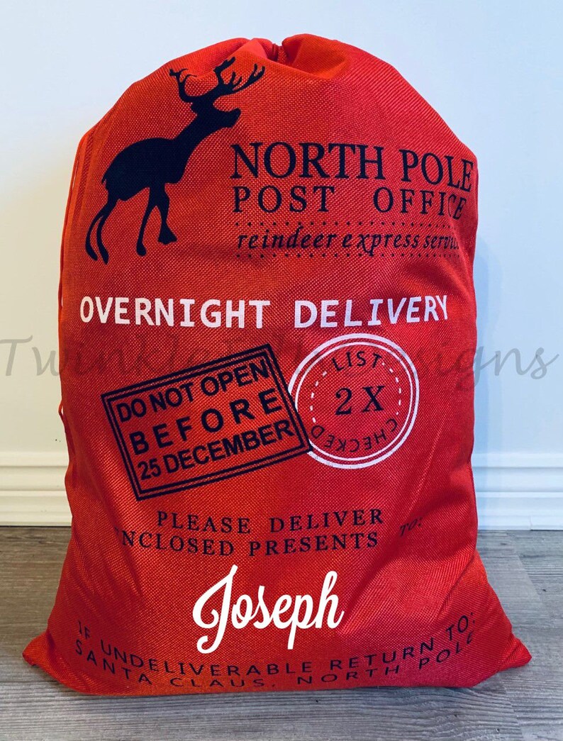 May include: Red Christmas gift sack with a black reindeer silhouette and the text "North Pole Post Office." The sack includes the text "Overnight Delivery" and "Do Not Open Before 25 December." The name "Joseph" is printed on the sack.