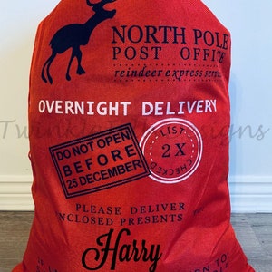 May include: Red Christmas gift sack with black text and a reindeer silhouette. Text includes "North Pole Post Office," "Overnight Delivery," "Do Not Open Before 25 December," and the name "Harry." A festive holiday gift bag.