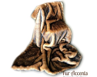 May include: A brown faux fur throw blanket with a soft, plush texture. The blanket is folded and draped over itself, showcasing its luxurious feel. Fur Accents Premium Faux Fur Throws.
