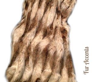 May include: A brown and white faux fur throw blanket with a chevron pattern. The blanket is folded and has a "Fur Accents" label on the right side.