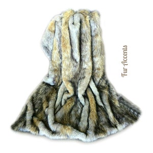 May include: A faux fur throw blanket in shades of brown, gray, and white. The blanket is folded and draped over a white background. The text "Fur Accents" is visible in the image.