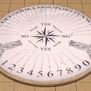 May include: Round, off-white Ouija board with a wooden rim. The board features the alphabet, numbers, and directional indicators like "Yes," "No," and "Maybe." A starburst design is in the center, with Celtic knotwork on the sides.