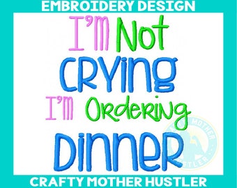 May include: Embroidery design with the text "I'm not crying I'm ordering dinner" in pink, green, and blue lettering. The design is for embroidery and is available for purchase.