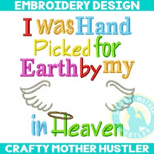 以下が含まれることがあります： 虹色の天使の羽根と後光が付いた「I was Hand Picked for Earth by my in Heaven」というテキストが刺繍されたデザイン。デザインは「Crafty Mother Hustler」というテキストが書かれた円に囲まれています。