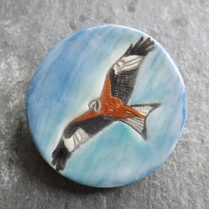 Handmade Ceramic Red Kite brooch on sky blue background