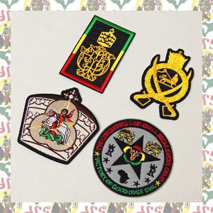 Puede incluir: Cuatro parches bordados con temática rastafari. Los parches presentan un león, una corona, una estrella y una figura a caballo. Los parches son todos en tonos de verde, rojo, amarillo y negro.