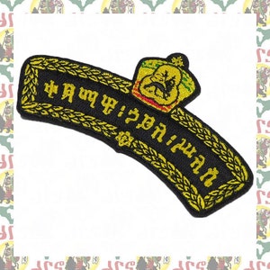 Puede incluir: Un parche bordado en negro y dorado con una corona y el texto "የኢትዮጵያ ጦር ሰራዊት" en amhárico.