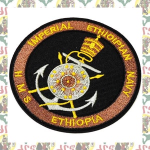 May include: A circular embroidered patch with a black background and a gold border. The patch features a silver anchor, a crown, and the text "Imperial Ethiopian Navy HMS Ethiopia".