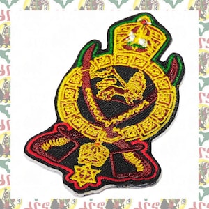 May include: Embroidered patch featuring a Rastafarian emblem with a lion, crown, and decorative elements in red, yellow, green, and black. The patch has a detailed design and a stitched border, suitable for clothing or accessories.