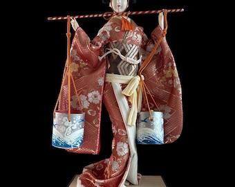 Japanese Geisha in Kimono Carrying Water Buckets Doll. This gorgeous and adorable geisha doll. Dressed in an opulent traditional costume.