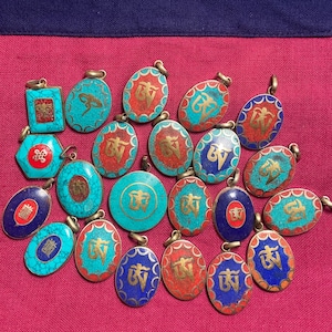 May include: A collection of 20 oval-shaped pendants with intricate designs. The pendants are made of metal and feature a variety of colors, including turquoise, blue, red, and gold. Each pendant has a different design, but they all feature a similar style. The pendants are perfect for adding a touch of style to any outfit.