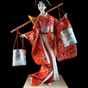 Japanese Geisha in Kimono Carrying Water Buckets Doll. This gorgeous and adorable geisha doll. Dressed in an opulent traditional costume.