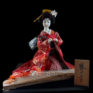 Japanese Geisha in Kimono Playing Koto. This doll is both gorgeous and adorable. The doll is dressed in an opulent traditional costume.