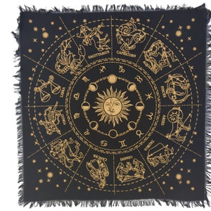 May include: Black tapestry with a gold zodiac wheel featuring the twelve astrological signs and the sun and moon. The tapestry has a fringed border.