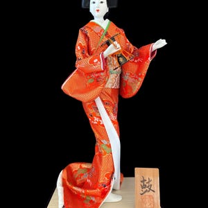 Drum Geisha Girl Doll This gorgeous and adorable geisha doll. Dressed in an opulent traditional costume.