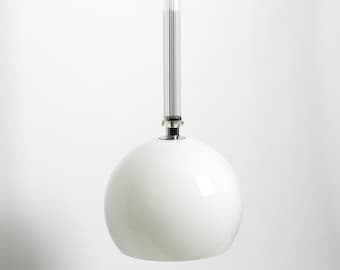 May include: A contemporary pendant light with a white, spherical lampshade. The light fitting has a clear, ribbed glass rod and chrome-coloured metal canopy and accents. The design is minimalist and elegant, suitable for various interior styles.