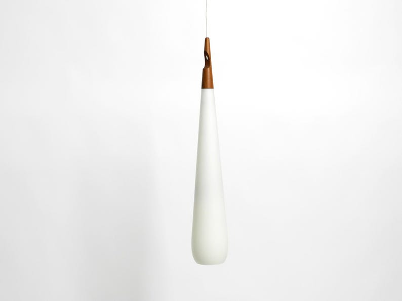 May include: A white teardrop-shaped pendant light with a wooden top.