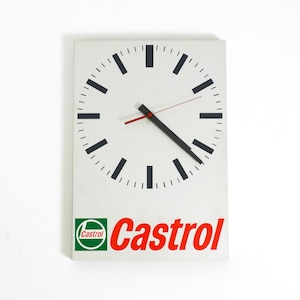 Könnte beinhalten: Rechteckige Wanduhr mit weißem Zifferblatt, schwarzen Stundenmarkierungen und schwarzen und roten Zeigern. Die Uhr zeigt unten das Castrol-Logo in Grün und Rot.