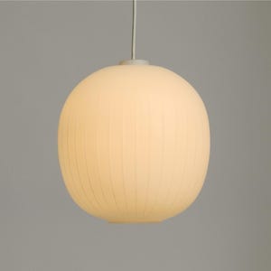 Puede incluir: Una l&aacute;mpara colgante redonda de color blanco roto con una textura acanalada. La l&aacute;mpara cuelga de un fino cable blanco y emite un brillo suave y c&aacute;lido. El dise&ntilde;o es simple y moderno, adecuado para varios estilos de interior.