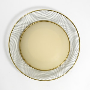 May include: A round, gold-colored ceiling light fixture with a white, fabric shade surrounded by a wire mesh.