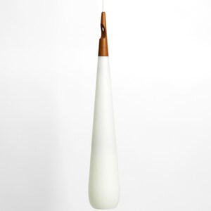 May include: A white teardrop-shaped glass pendant light with a wooden top.
